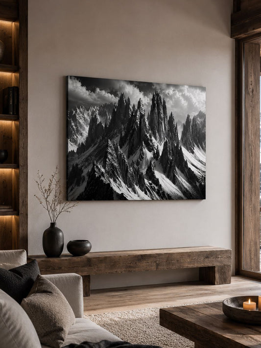Paysage de haute montagne en noir et blanc composé de pics rocheux, neige et nuages dans une ambiance majestueuse
