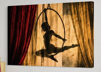 Tableau acrobate sur cerceau dans une ambiance de spectacle aux rideaux rouges et lumière chaleureuse
